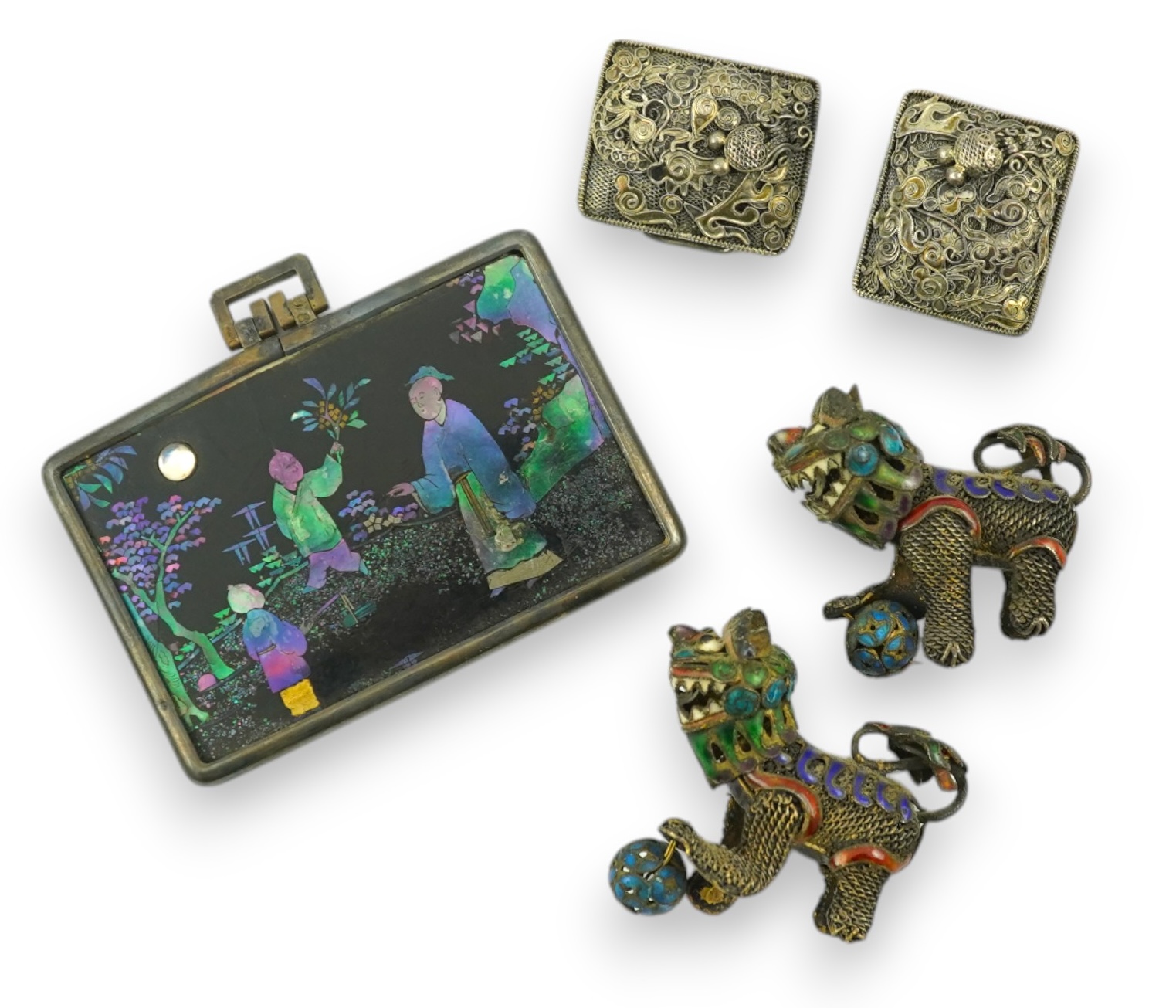 A Chinese silver buckle with filligree butterfly decoration, a pair of enamelled miniature lion dogs with balls and a small lac burgaute panel. Lion dogs 4.5cm long. Condition - good